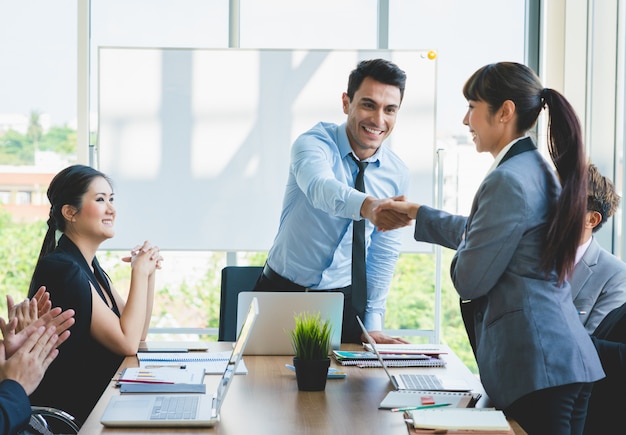 Gente de negocios dándose la mano enhorabuena al éxito laboral.