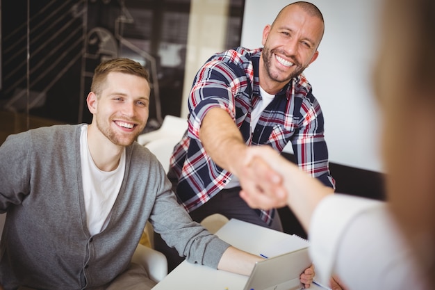 Gente de negocios dándose la mano en la oficina creativa