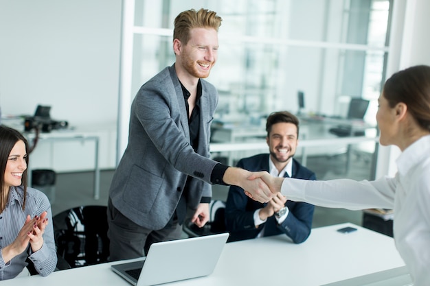 Gente de negocios dándose la mano en la oficina