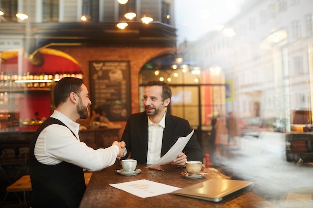 Gente de negocios dándose la mano en el restaurante