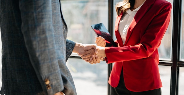 Gente de negocios dándose la mano durante una reunión en una oficina moderna