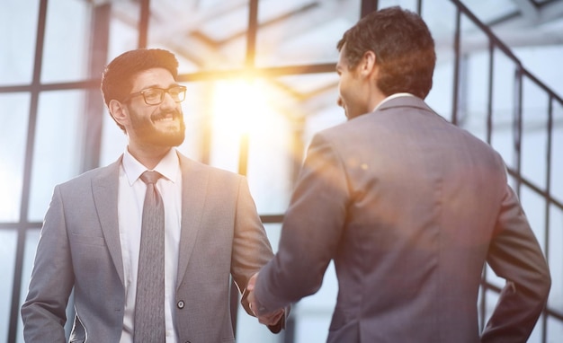 Gente de negocios dándose la mano terminando una reunión en una oficina moderna