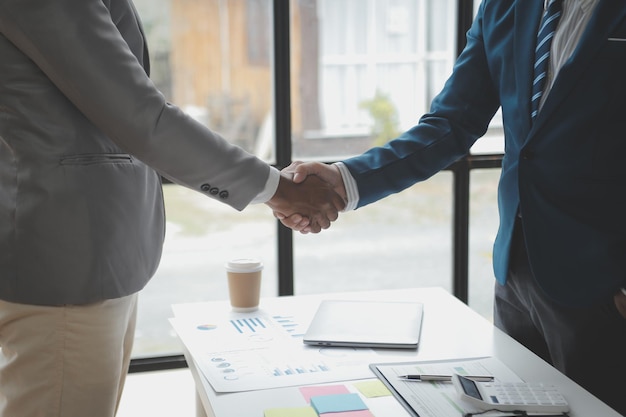 Gente de negocios dándose la mano, terminando una reunión