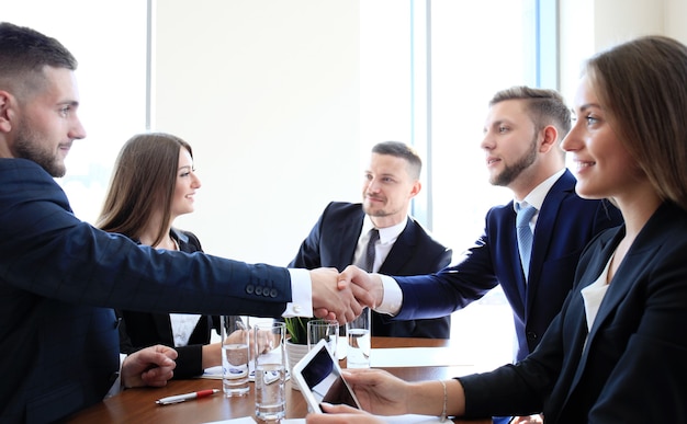 Gente de negocios dándose la mano, terminando una reunión