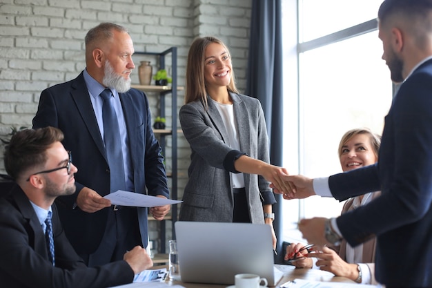 Gente de negocios dándose la mano, terminando una reunión