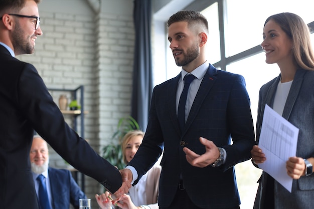 Gente de negocios dándose la mano, terminando una reunión