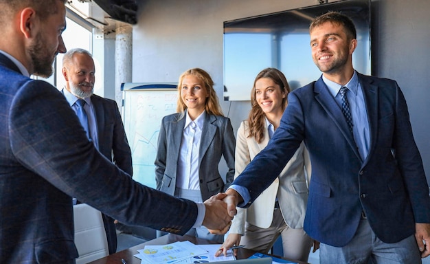 Foto gente de negocios dándose la mano, terminando una reunión