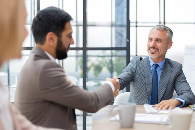 Gente de negocios dándose la mano, terminando una reunión