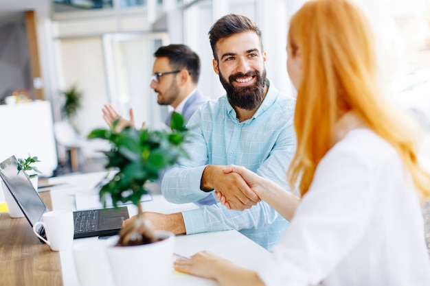 Gente de negocios dándose la mano y terminando una reunión