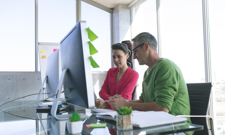 Foto gente de negocios discutiendo en la computadora en el escritorio de la oficina
