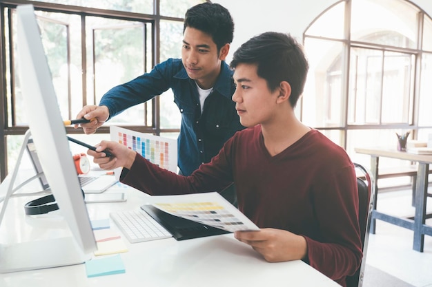 Gente de negocios discutiendo en la computadora mientras están sentados en la mesa