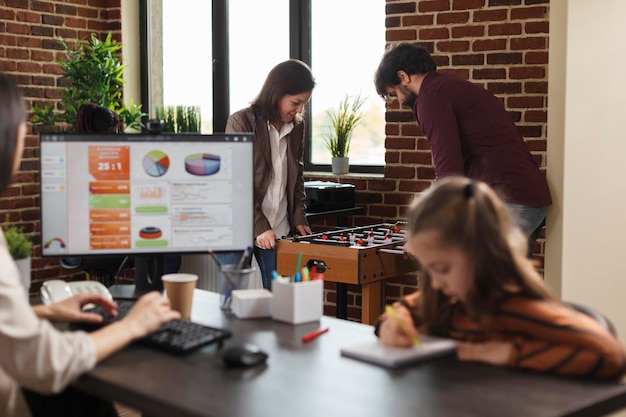 Gente de negocios de la empresa jugando al futbolín durante el tiempo de descanso. Compañeros de trabajo en el lugar de trabajo disfrutando del tiempo libre juntos mientras tienen una competencia de fútbol de mesa en el espacio de trabajo.