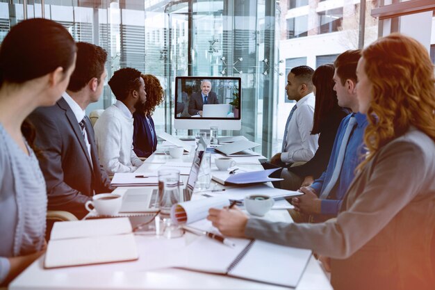 Gente de negocios enfocada mirando la pantalla durante la videoconferencia