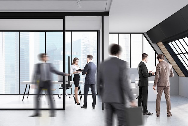 La gente de negocios está de pie y caminando en una oficina de ático con paredes de vidrio y mesas de computadora.