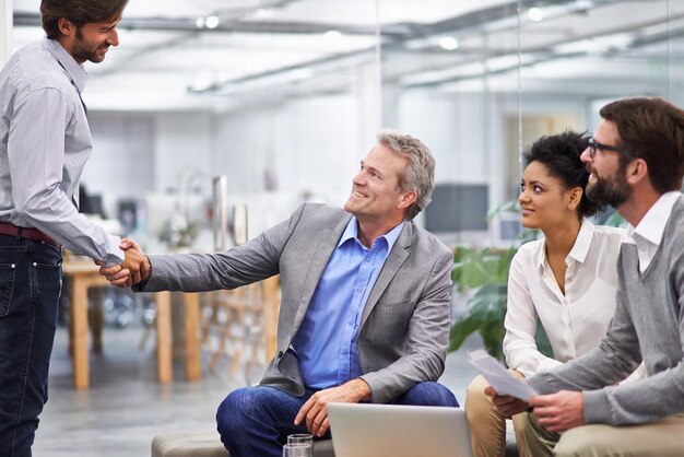 Foto gente de negocios se estrecha la mano y se reúne con el equipo para un acuerdo de asociación o b2b en la oficina empresario o empleados se estrechan la mano para saludar un acuerdo o colaboración en una discusión en el lugar de trabajo