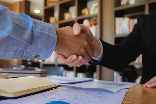 Foto gente de negocios estrechando la mano en la mesa