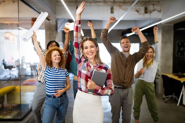 Gente de negocios feliz celebrando el éxito en la oficina de la empresa