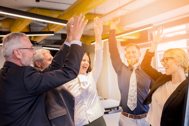 Gente de negocios feliz celebrando su éxito en la oficina