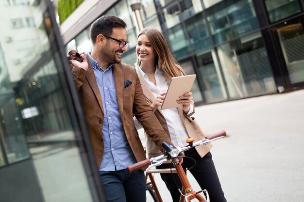 Foto gente de negocios feliz discutiendo y sonriendo mientras camina junto al aire libre