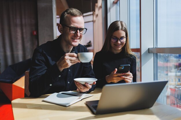 La gente de negocios feliz está sentada en la mesa hablando riéndose discutiendo documentos de negocios colegas sonrientes están colaborando en la oficina en una sesión informativa con una lluvia de ideas en una reunión