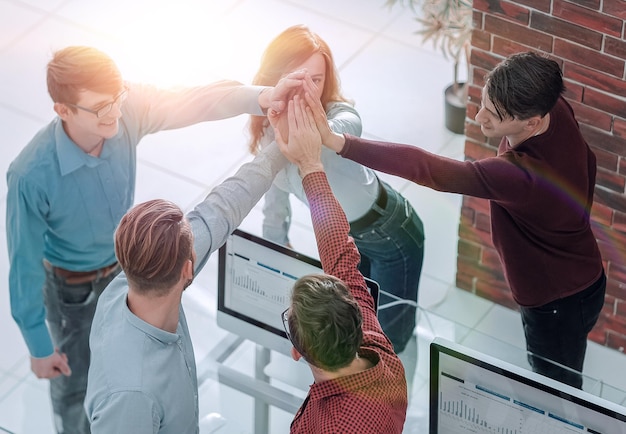 Gente de negocios feliz mostrando trabajo en equipo y dando cinco en ofic