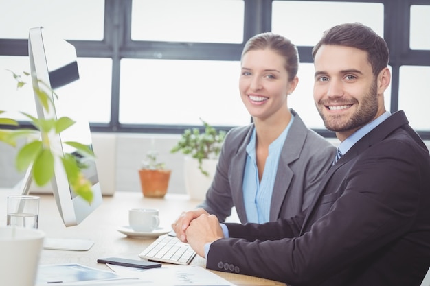 Gente de negocios feliz trabajando en la computadora en el escritorio