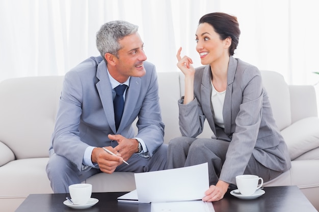 Gente de negocios feliz trabajando y hablando juntos en el sofá