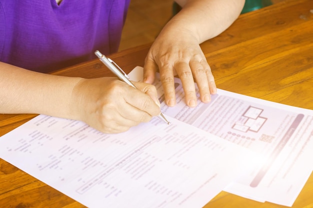 Gente de negocios firmando documentosManos de mujer de negocios escribiendo en papel en el escritorio