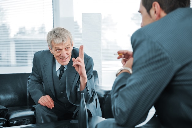 Gente de negocios hablando mientras que el jefe está señalando con el dedo