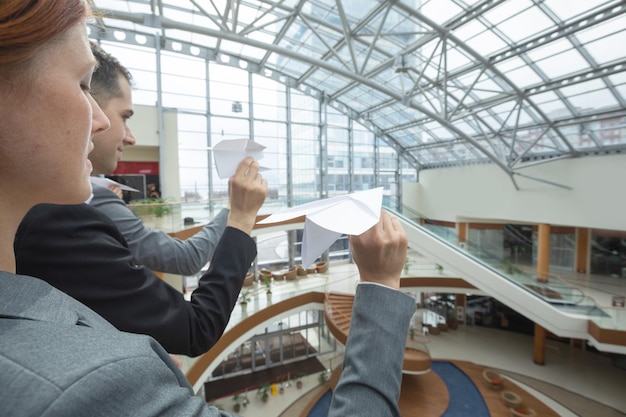 Gente de negocios lanzando aviones de papel