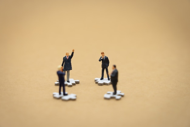 Gente de negocios en miniatura personas de pie en blanco Jigsaw