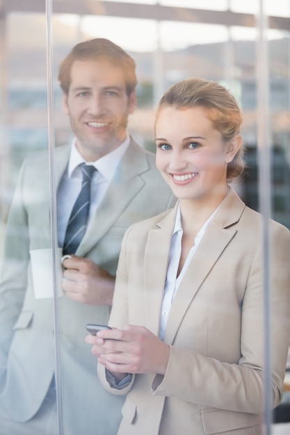 Gente de negocios mirando a la cámara a través de la ventana