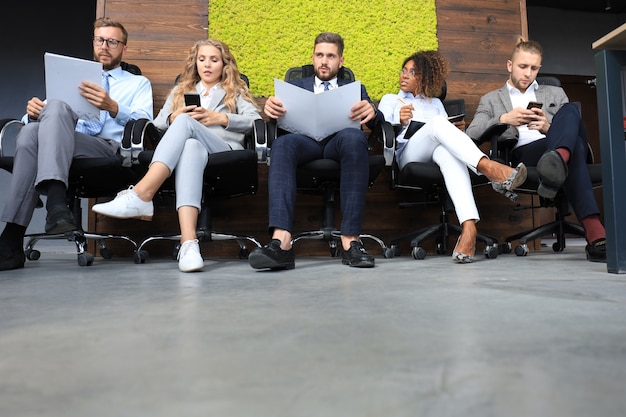 Foto gente de negocios moderna esperando una entrevista de trabajo.