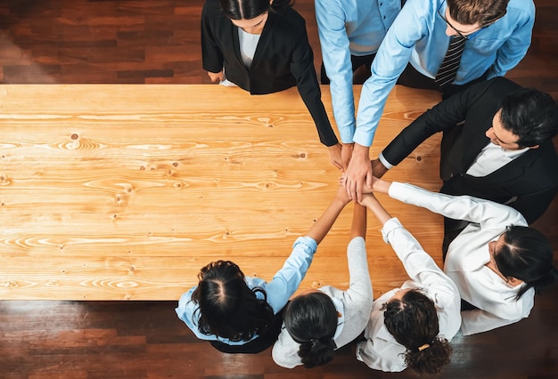 Gente de negocios multirracial hace sinergia mano apilada juntos en la sala de reuniones como cooperación o team building para empleado corporativo en el lugar de trabajo panorámica vista superior meticuloso