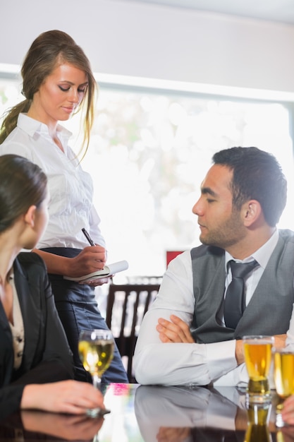 Gente de negocios ordenando una cena de la camarera