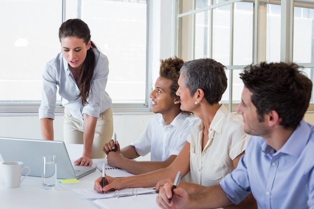 Gente de negocios que usa computadoras portátiles y cuadernos en reunión