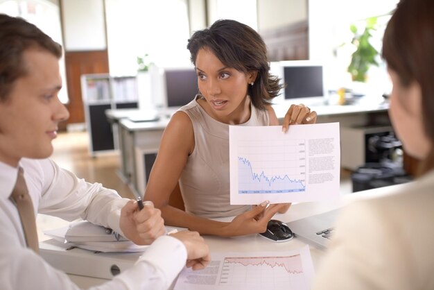 Foto gente de negocios reunión datos papeleo y mujer muestra ventas gráfico de retroalimentación estadísticas financieras comerciales o análisis económicos discusión en grupo de trabajo en equipo y cooperación del personal en el gráfico financiero de la empresa