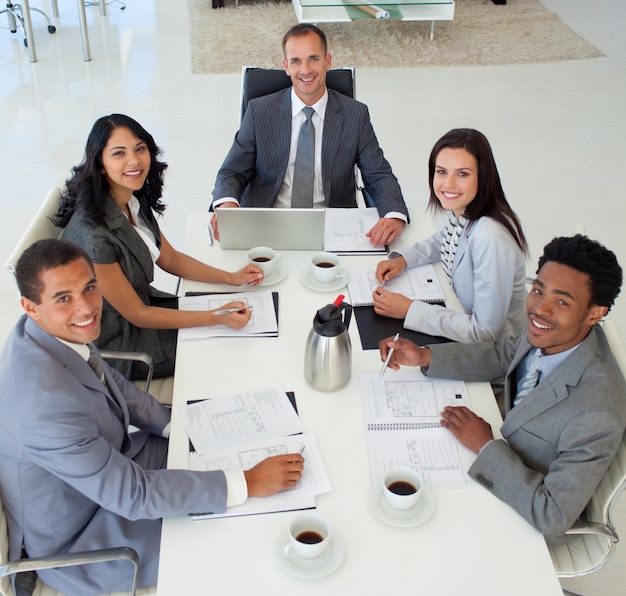 Gente de negocios en una reunión sonriendo a la cámara