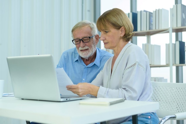 Gente de negocios senior caucásica trabajando y haciendo una lluvia de ideas en la oficina moderna