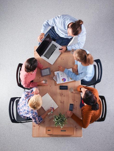 Foto gente de negocios sentada y discutiendo en una reunión en la oficina