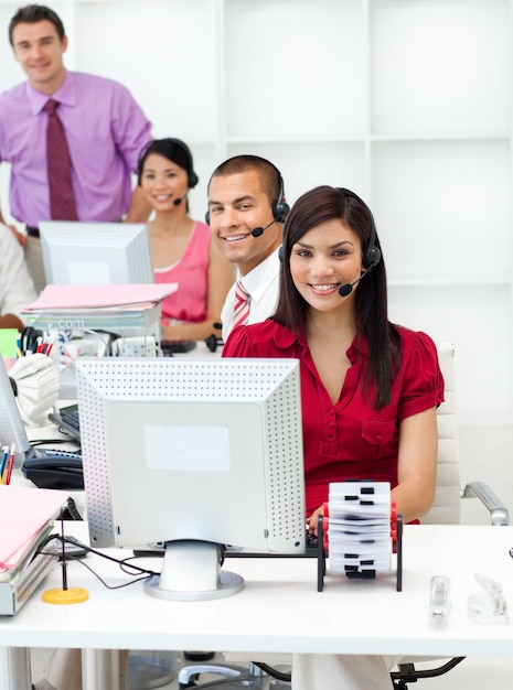 Gente de negocios sonriente con auriculares trabajando