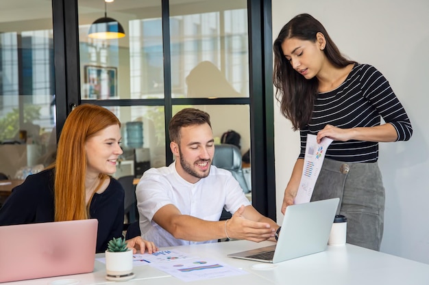 Gente de negocios trabajando en una computadora portátil en la oficina y reuniéndose con un colega