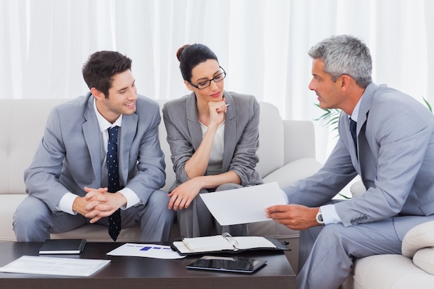 Gente de negocios trabajando y hablando juntos en el sofá