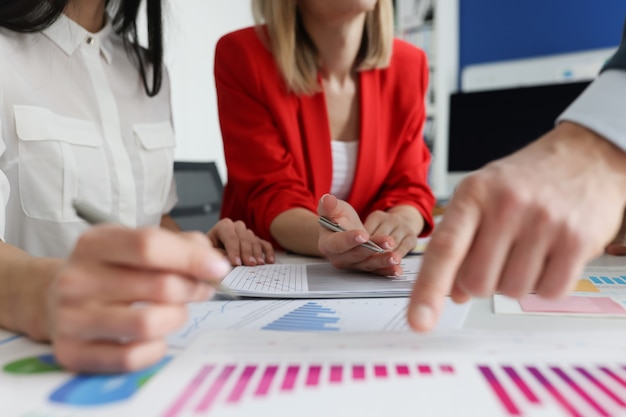 Gente de negocios en trajes discutiendo datos sobre gráficos de primer plano. Concepto de reunión de negocios