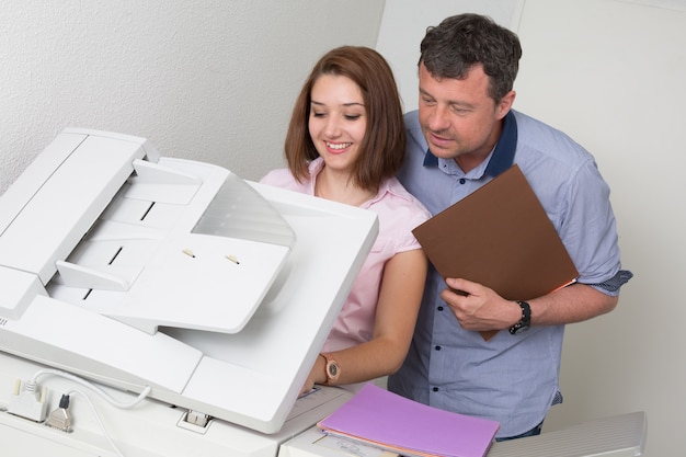 Gente de negocios utilizando una copiadora en el trabajo