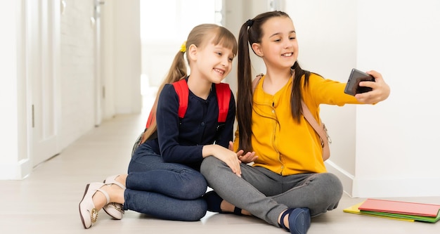 gente, niños, tecnología, amigos y concepto de amistad - niñas felices con smartphones tirados en el suelo en casa.