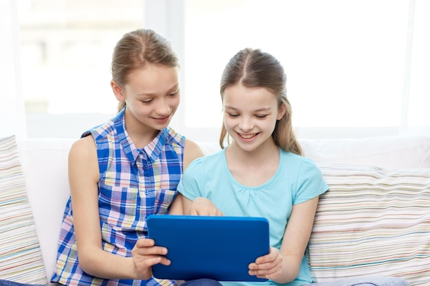 gente, niños, tecnología, amigos y concepto de amistad - niñas felices con tablet pc sentadas en un sofá en casa