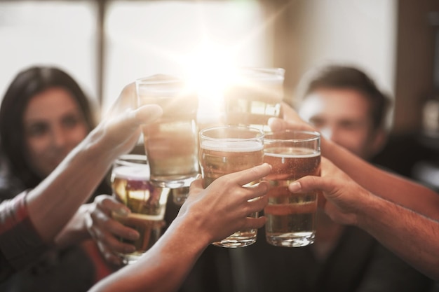 gente, ocio, amistad y concepto de celebración - amigos felices bebiendo cerveza de barril y vasos tintineantes en el bar o pub