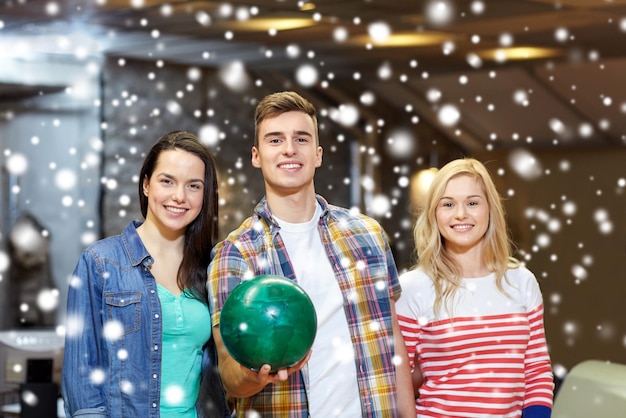 gente, ocio, deporte, amistad y concepto de entretenimiento - amigos felices en el club de bolos en la temporada de invierno