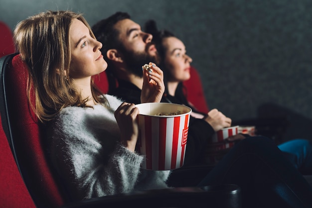 Gente con palomitas de maíz disfrutando de la película